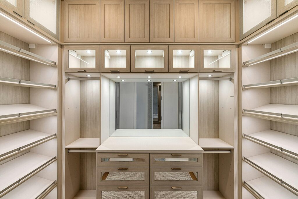 Spacious walk-in closet with wooden cabinets and ample lighting.